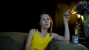 A brunette seductress sucks on a cigarette while she watches you