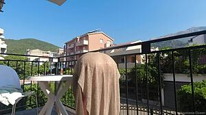 Topless beauty enjoys the outdoors on her balcony