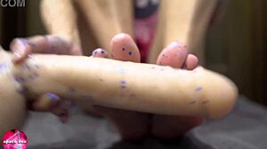Babe performs sensual footjob with rubber cock