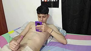 Young Colombian jerks off to Spanish porn on his phone, stepmom helps out