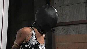 Suspended Ebony Slut Faces Harsh Punishment in Garage Bondage Scene.