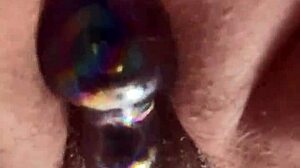 A close-up view of a girl masturbating with a glass toy