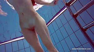 Martina in a blue bikini underwater, tightening her pussy