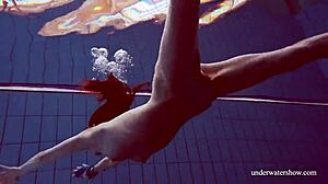 Martina in a blue bikini underwater, tightening her pussy