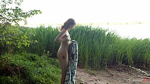 Beside the lake, teen redhead Mia fingers her shaved pussy to a wild orgasm.