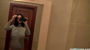 busty babe fingers her hairy pussy in the bathroom