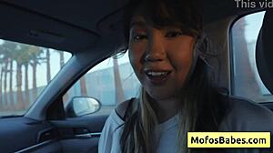 Sexy asian hottie plays with natural big boobs in car