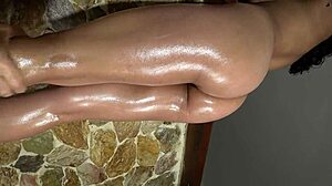 Detailed view of oiled beautiful butt and legs in red and dark blue panties during massage