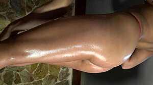 Detailed view of oiled beautiful butt and legs in red and dark blue panties during massage