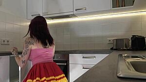 Hey check out this hot redhead tattooed cheerleader in over knee socks revealing her see through panties in the kitchen