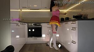 Hey check out this hot redhead tattooed cheerleader in over knee socks revealing her see through panties in the kitchen