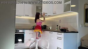 Hey check out this hot redhead tattooed cheerleader in over knee socks revealing her see through panties in the kitchen