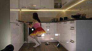 Hey check out this hot redhead tattooed cheerleader in over knee socks revealing her see through panties in the kitchen