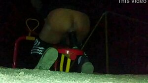 transexual explores outdoor anal masturbation with a dildo in her ass at a public plaza, feeling the thrill.