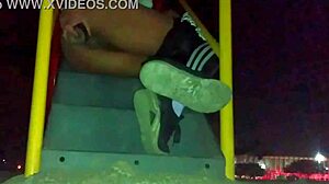 transexual explores outdoor anal masturbation with a dildo in her ass at a public plaza, feeling the thrill.