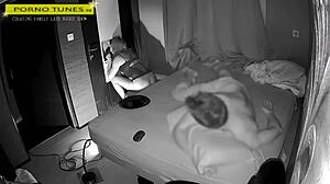 Mature wife visits gloryhole for fan encounters while husband naps nearby in homemade fetish scene.