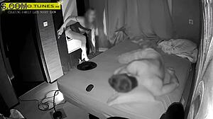 Mature wife visits gloryhole for fan encounters while husband naps nearby in homemade fetish scene.