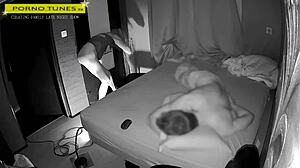 Mature wife visits gloryhole for fan encounters while husband naps nearby in homemade fetish scene.