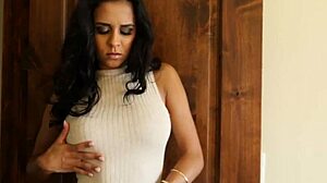 Glamcore babe in bikini strips on sofa with long hair and tattoo