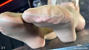 mistress's beautiful feet in flesh-colored pantyhose tease you close-up on the desk