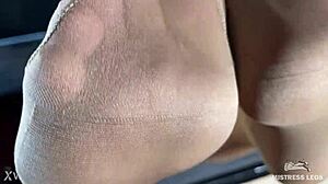 mistress's beautiful feet in flesh-colored pantyhose tease you close-up on the desk