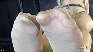 mistress's beautiful feet in flesh-colored pantyhose tease you close-up on the desk