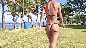 Skinny brunette strips panties and teases hairy pussy on public beach