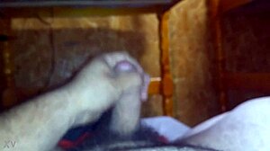 guy strokes his hard cock furiously on the bed