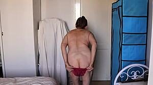 In the garage, mature blonde sheds red lace for teasing striptease