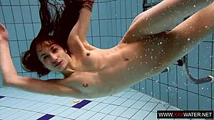 brunette cutie janka with long hair swims underwater in pool