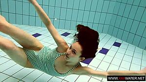 brunette cutie janka with long hair swims underwater in pool