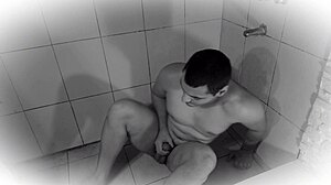Golden rain drenches muscular man's huge cock in shower