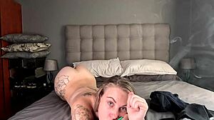Tattooed blonde smokes naked after undressing